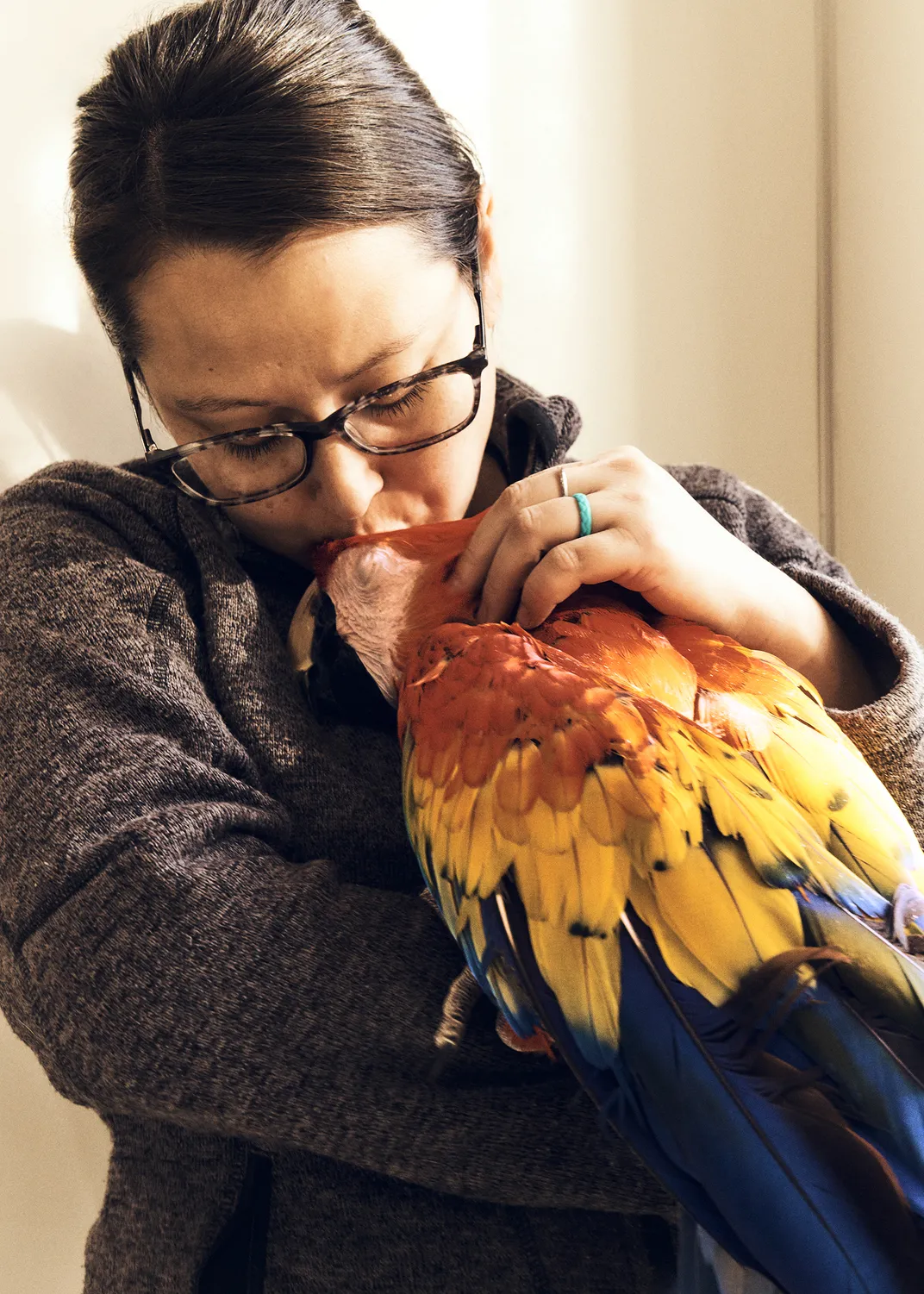 Caregiver Kaila Dondlinger attends to Pepper, a 26-year-old scarlet macaw. Many birds at Best Friends’ Parrot Garden have experienced multiple ownership and some have outlived their previous owners.